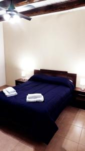 1 dormitorio con 1 cama azul y 2 toallas en Departamento en zona Alto Maipú en Maipú