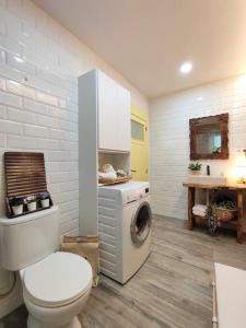 a bathroom with a toilet and a washing machine at Casa Alicia in Gijón