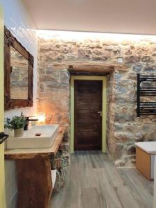 a bathroom with a sink and a stone wall at Casa Alicia in Gijón