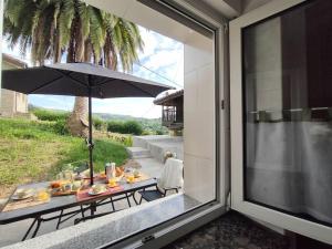 a dining table with an umbrella on a patio at Casa Alicia in Gijón