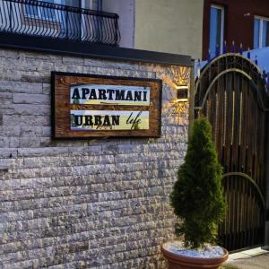 a sign on the side of a brick wall with a tree at Spa Apartman OGLEDALO in Zaječar