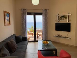 un soggiorno con divano e vista sull'oceano di Anemos-Halcyon-Eirene a Mochlos