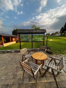 a table and chairs and a table and a gazebo at Apartments and Rooms Kristina in Drežnik Grad