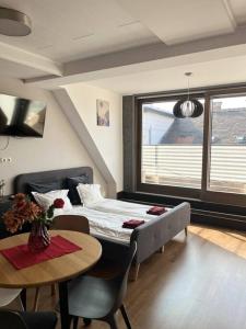 1 dormitorio con cama, mesa y ventana en Sunny/stylish rooftop home/private balcony shared jacuzzi en Budapest