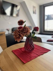 un jarrón con flores en él sentado en una mesa en Sunny/stylish rooftop home/private balcony shared jacuzzi en Budapest