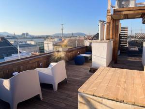 een balkon met een tafel en stoelen op een dak bij Sunny/stylish rooftop home/private balcony shared jacuzzi in Boedapest