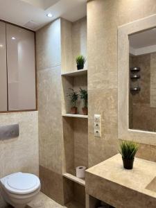 een badkamer met een toilet en een wastafel met planten bij Sunny/stylish rooftop home/private balcony shared jacuzzi in Boedapest