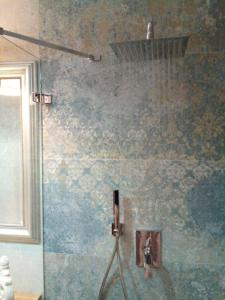 eine Dusche mit einem an der Wand befestigten Schlauch in der Unterkunft Schönes Altstadt-Apartment ''Dolce Vita'' inkl Parkplatz in Riva del Garda
