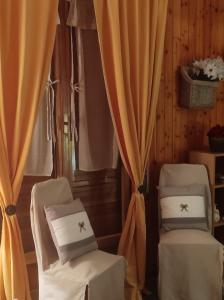 two chairs in a room with curtains at Orchidea in Frabosa Soprana
