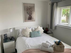 Un dormitorio con una cama blanca con toallas. en Beautiful home in South Queensferry, en Queensferry