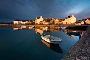 a boat is docked in the water next to houses at Maison au calme à l'intérieur du golf de Ploëmel, entre terre et mer, 2 chambres, 10 min des plages in Ploemel