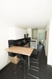 a kitchen with a wooden table and two bar stools at Maison au calme à l'intérieur du golf de Ploëmel, entre terre et mer, 2 chambres, 10 min des plages in Ploemel