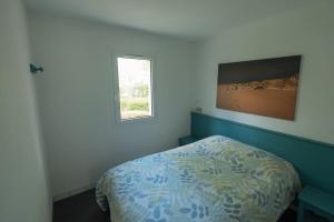 Schlafzimmer mit einem Bett und einem Fenster in der Unterkunft Maison au calme à l'intérieur du golf de Ploëmel, entre terre et mer, 2 chambres, 10 min des plages in Ploemel