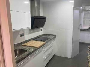 een keuken met een aanrecht met een wastafel en een koelkast bij Atico Avila in Avila