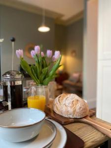 a table with a bowl of bread and a bowl of orange juice at Fabulous flat in Durnford Street in Plymouth