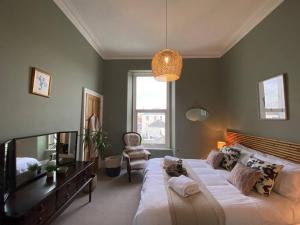 a bedroom with a large bed and a chair at Fabulous flat in Durnford Street in Plymouth
