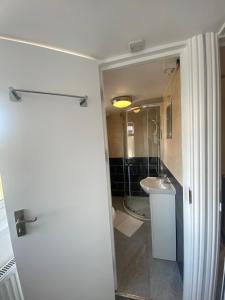 uma casa de banho com um chuveiro, um lavatório e um WC. em Cosy house in Newham em Londres