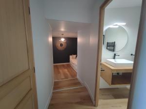 La salle de bains est pourvue d'un lavabo et d'un miroir. dans l'établissement Le Gîte de Daisy, à Saint-Côme-du-Mont