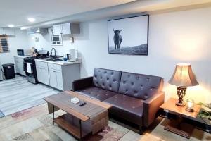 uma sala de estar com um sofá e uma cozinha em Spacious Suite Close to Downtown Indy/ King Bed em Indianápolis