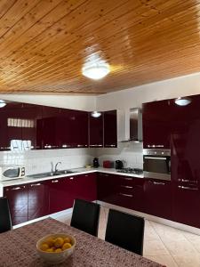 a kitchen with purple cabinets and a bowl of oranges on a table at Da Delfo in Agnone Bagni