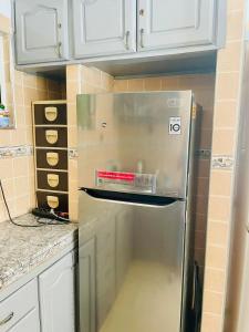 a stainless steel refrigerator in a kitchen with white cabinets at STAR APPARTEMENT GAUTHIER in Casablanca