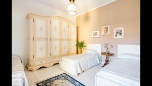 a bedroom with two beds and a dresser at B&B Maison Rosetta IUN-E4948 in Nuoro