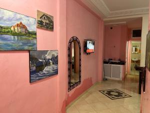 un pasillo rosa con pinturas en la pared en Dar Diafa-Imouzzer Kandar, en Imouzzer Kandar