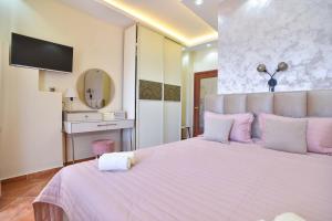 a bedroom with a large white bed with purple pillows at Beach House in Petrovac na Moru