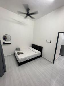 Jest to biały pokój z łóżkiem i wentylatorem sufitowym. w obiekcie Ayra De Villa -Ayra Homestay 9-bedroom with Private Pool w mieście Shah Alam