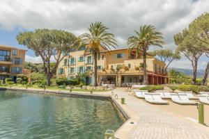 a resort with a pool and chairs and palm trees at Casa Santini x Roc Seven in Porto-Vecchio