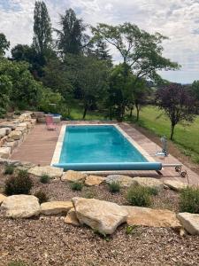 una piscina in mezzo a un giardino con rocce di Cabane du Canada ad Azerat