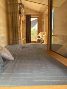ein Schlafzimmer mit einem großen Bett in einem Blockhaus in der Unterkunft Cabane du Canada in Azerat