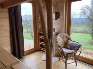 a room with a chair in front of a window at Cabane du Canada in Azerat