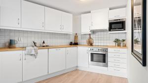 a white kitchen with white cabinets and appliances at Very central location in Bergen in Bergen