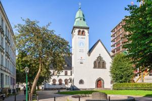 a church with a tower with a clock on it at Very central location in Bergen in Bergen