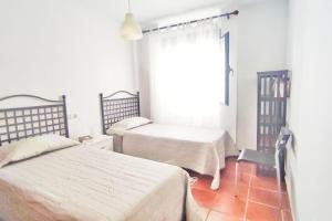 1 dormitorio con 2 camas y ventana en Casa Piedra Blanca, en Rodalquilar