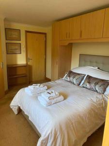 a bedroom with a white bed with towels on it at Apartment 500 - Metro style apartment on NC500 in Thurso