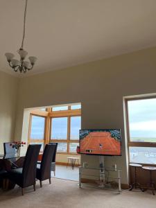 a living room with a tv and a table with chairs at Apartment 500 - Metro style apartment on NC500 in Thurso