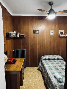 1 dormitorio con 1 cama y pared de madera en Casa iaia, en Monistrol