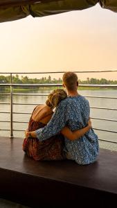 un hombre y una mujer sentados en un barco mirando el agua en Kera Houseboats Alleppey, en Alleppey
