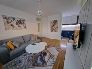 ein Wohnzimmer mit einem Sofa und einem Tisch in der Unterkunft Apartman Juba in Lukavica