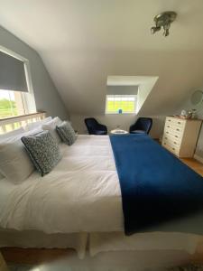 a bedroom with a large white bed with two chairs at Green Haven V93P230 in Killarney