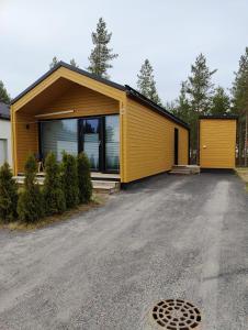 une maison jaune avec une allée dans l'établissement Minikoti, à Oulu