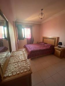 - une chambre avec un lit et 2 tables dans l'établissement Appartement avec magnifique piscine face à la mer, à Minaret de Mansuria