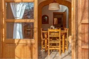 a dining room with a wooden table and chairs at SA FONTETA in S'Illot