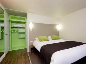 a hotel room with a bed and green shelves at Campanile Versailles Buc in Buc