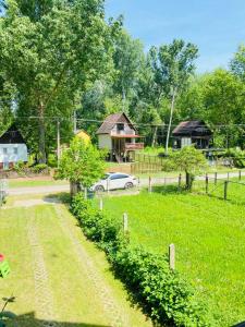 Rakamaz的住宿－Tisza-Parti Rönkház Tokaj，农场,有车停在田里