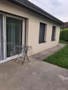 une table en verre devant une maison dans l'établissement Studio calme dans villa habitée, parking disponible et sûr, à Rhut