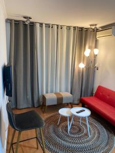 sala de estar con sofá rojo y silla roja en M-Montt Providencia Apartamentos Amoblados, en Santiago