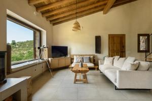 a living room with a couch and a tv at Cerrás Agroturismo in Jerte